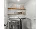 Laundry room equipped with modern washer and dryer, and wooden shelving at 1713 Shamrock Dr, Charlotte, NC 28205