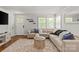 Inviting living room with a large sectional sofa, decorative rug, and plenty of natural light from multiple windows at 1713 Shamrock Dr, Charlotte, NC 28205