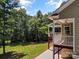 Inviting back porch with white railing, ceiling fan, and a peaceful view of the green lawn and woods at 1819 Brompton Ct, Newton, NC 28658