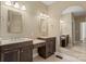 Bathroom featuring double sinks with dark wood cabinets, a vanity area, and an arched mirror at 1819 Brompton Ct, Newton, NC 28658