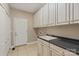 Well-equipped laundry room featuring white cabinets, a sink, and a door leading to the exterior at 1819 Brompton Ct, Newton, NC 28658