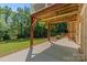 Covered patio with wood supports and a view of the fenced backyard and lush greenery at 1819 Brompton Ct, Newton, NC 28658