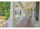 Covered front porch featuring wood chairs, a ceiling fan, and views of the yard at 1819 Brompton Ct, Newton, NC 28658