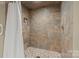 Shower with stone-look tile and a pebble floor, featuring a white shower curtain at 1819 Brompton Ct, Newton, NC 28658