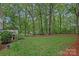 Lush backyard with mature trees, a wooden fence, and a deck, perfect for outdoor enjoyment and entertaining at 20312 Deep Cove Ct, Cornelius, NC 28031
