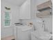 Well-lit laundry room featuring a utility sink, washer, dryer, and ample storage cabinets at 20312 Deep Cove Ct, Cornelius, NC 28031