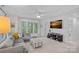 Cozy living room with a comfortable gray sofa, large windows, and a mounted TV at 20312 Deep Cove Ct, Cornelius, NC 28031