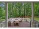 Inviting outdoor seating area on a deck, featuring a comfortable sectional sofa and wooded views for relaxation at 20312 Deep Cove Ct, Cornelius, NC 28031