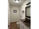 Bathroom featuring wood-look floors, white vanity with sink, toilet, and mirror with decorative black frame at 205 Wellington Hills Cir # 205, Salisbury, NC 28147