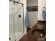 Bathroom featuring glass shower door, dark sink vanity, wood-look floors and a light-blue towel at 205 Wellington Hills Cir # 205, Salisbury, NC 28147