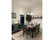 Dining area features stylish green chairs and decorative sideboard, with ample lighting and an open view to the kitchen at 205 Wellington Hills Cir # 205, Salisbury, NC 28147
