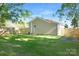 Large, fenced backyard with lush green grass and mature trees providing ample shade and privacy at 210 E 5Th Ave, Gastonia, NC 28054