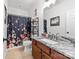 Well-lit bathroom features a floral shower curtain, granite vanity, decorative mirror, and neutral tile flooring at 212 Victoria Cir, York, SC 29745