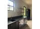 Stylish bar area with dark cabinets, beverage cooler, floating wood shelves, and a modern sink at 2412 Kingsbury Dr, Charlotte, NC 28205