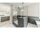 A modern bath with glass enclosed shower, marble tile, gray accent wall, and marble floors at 2412 Kingsbury Dr, Charlotte, NC 28205