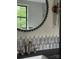 Stylish bathroom with a round mirror, unique tile backsplash, and modern gold fixtures at 2412 Kingsbury Dr, Charlotte, NC 28205