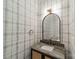 Chic powder room with black and white plaid wallpaper, a marble countertop and a gold-trimmed mirror at 2412 Kingsbury Dr, Charlotte, NC 28205