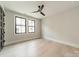 Bright bedroom showcasing hardwood floors, neutral walls, a ceiling fan, and two large windows at 2412 Kingsbury Dr, Charlotte, NC 28205