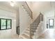 Hallway with elegant staircase, modern black railings and light hardwood floors at 2412 Kingsbury Dr, Charlotte, NC 28205