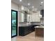 Bright, modern kitchen featuring white cabinets, black island, stainless steel appliances, and hardwood floors at 2412 Kingsbury Dr, Charlotte, NC 28205