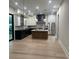 Open kitchen featuring white cabinets, black island, stainless steel appliances, and hardwood floors at 2412 Kingsbury Dr, Charlotte, NC 28205