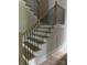 Staircase featuring hardwood steps, white risers, and a black iron railing at 2412 Kingsbury Dr, Charlotte, NC 28205