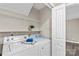 Bright laundry area with white washer and dryer, storage shelves, and convenient access to other parts of the home at 270 Yachtsman Dr, Salisbury, NC 28146