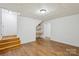 Finished basement with wood-look floors, shelving, access to lower level, and neutral walls at 3090 Goblet Rd, Richburg, SC 29729