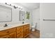 Bathroom with double vanity sink, wood cabinets, black hardware, and a window view at 3090 Goblet Rd, Richburg, SC 29729