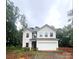 Charming two-story home features a large garage and classic architectural details, nestled amid lush trees at 3248 Killian Rd, Lincolnton, NC 28092
