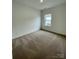 A tidy bedroom with neutral carpeting and natural light, providing a comfortable and serene atmosphere at 353 Jetton St, Davidson, NC 28036