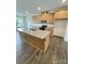 Open kitchen with island, granite counters, wood cabinets, and stainless appliances at 353 Jetton St, Davidson, NC 28036