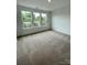 Well-lit living room featuring carpeted floors and multiple windows for natural light at 353 Jetton St, Davidson, NC 28036