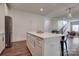 Open concept kitchen with white cabinets and island, stainless steel fridge, and hardwood floors at 360 Sundown Rd, Mooresville, NC 28117