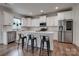Bright kitchen features white cabinets, stainless steel appliances, and a center island with breakfast bar seating at 360 Sundown Rd, Mooresville, NC 28117