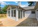 A home's back porch shows a sun room addition with sliding glass doors and a wooden deck, offering a great outdoor living space at 3801 Rea Rd, Charlotte, NC 28226