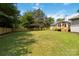 Spacious backyard with a well-maintained lawn, wooden privacy fence, and view of the home's back porch at 3801 Rea Rd, Charlotte, NC 28226
