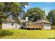 A view of the back of the property featuring a sunroom, back deck, and garage, all surrounded by a lush lawn at 3801 Rea Rd, Charlotte, NC 28226