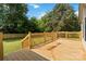 Back deck features wood railing, stairs to the lawn, and mature trees, enhancing the outdoor space at 3801 Rea Rd, Charlotte, NC 28226