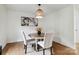 Bright dining room features wood floors, a round table with white chairs, and a stylish light fixture at 3801 Rea Rd, Charlotte, NC 28226