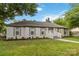 Beautiful single-story home showcasing a well-maintained lawn, decorative shutters and mature trees at 3801 Rea Rd, Charlotte, NC 28226