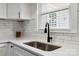 Close up of kitchen sink with white countertops and cabinets, stainless steel appliances and white subway tile at 3801 Rea Rd, Charlotte, NC 28226