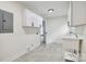 Bright laundry room with storage cabinets, sink and tile floor at 3801 Rea Rd, Charlotte, NC 28226