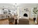 Inviting living room featuring a white brick fireplace, stylish lighting, and an open layout into the kitchen at 3801 Rea Rd, Charlotte, NC 28226