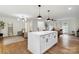 Open-concept living space with a kitchen island, modern lighting, and hardwood floors at 3801 Rea Rd, Charlotte, NC 28226
