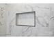 White marble tiled shower niche with decorative tile and black trim at 3801 Rea Rd, Charlotte, NC 28226
