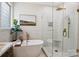 Bright bathroom features a modern soaking tub with gold faucet and a glass-enclosed shower with rainfall showerhead at 4121 Cedar Point Ave # 28, Stallings, NC 28104