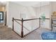 Upper level landing with a wood-trimmed railing, a chandelier, and carpeted floors at 4121 Cedar Point Ave # 28, Stallings, NC 28104