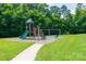 Community playground featuring a slide, swings, and climbing structures, surrounded by green grass and mature trees at 4121 Cedar Point Ave # 28, Stallings, NC 28104