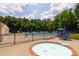 Inviting community pool with a separate hot tub area, sun loungers, and shady umbrellas for a relaxing atmosphere at 4121 Cedar Point Ave # 28, Stallings, NC 28104